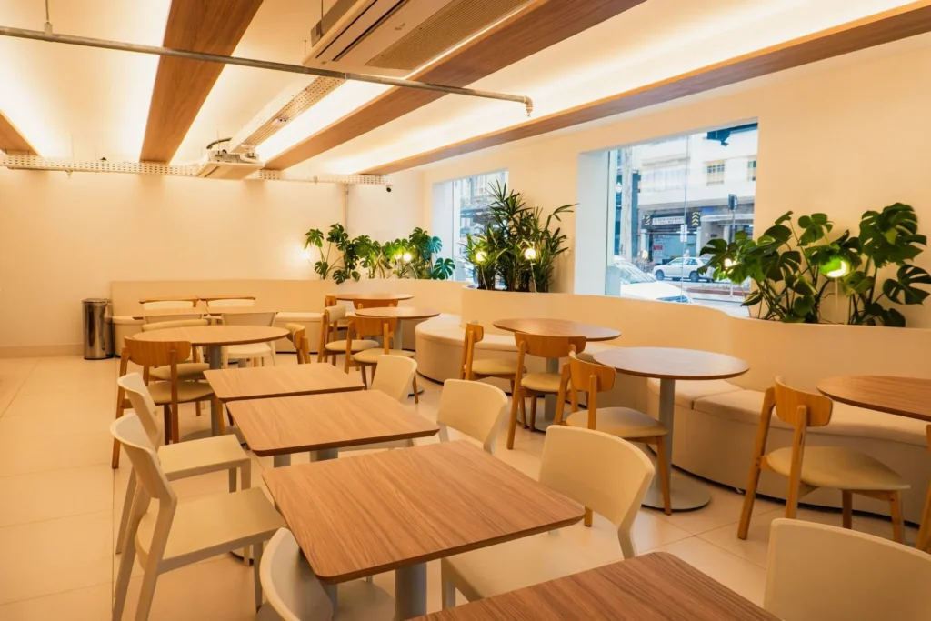 Restaurante com mesas e forro em madeira, projeto da Navarro Móveis Planejados no Moov Hotel São Paulo