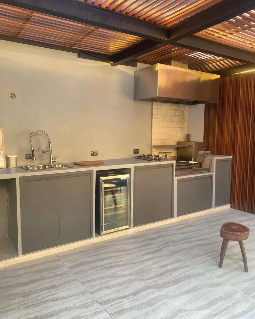 Área gourmet com bancada, adega e pergolado em madeira — projeto da Navarro Móveis Planejados