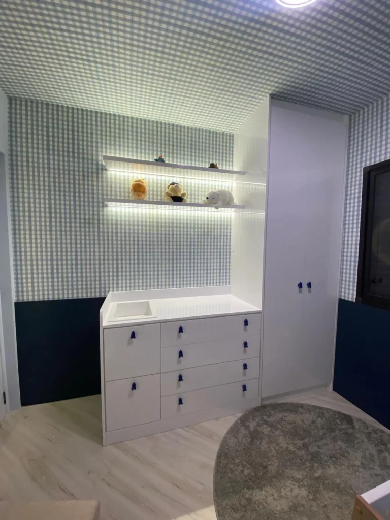 Quarto de bebê com cômoda trocador, roupeiro e prateleiras iluminadas — projeto da Navarro Móveis Planejados
