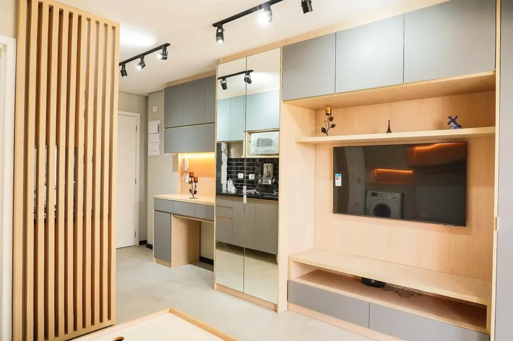 Studio planejado com painel de TV, armários e divisória ripada em madeira, projeto da Navarro Móveis Planejados